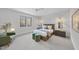 Bright bedroom with a queen bed, two green ottomans, and a large window at 7640 Falls Creek Ln, Raleigh, NC 27614