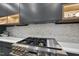 Gas cooktop with stainless steel range hood and herringbone backsplash at 7640 Falls Creek Ln, Raleigh, NC 27614