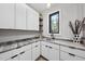 Modern laundry room with white cabinets, granite countertops, and a window at 7640 Falls Creek Ln, Raleigh, NC 27614