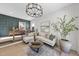 L-shaped sectional sofa, large windows, and a modern chandelier at 7640 Falls Creek Ln, Raleigh, NC 27614