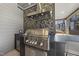 Stainless steel grill and modern tile backsplash in outdoor kitchen at 7640 Falls Creek Ln, Raleigh, NC 27614