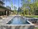 Beautiful backyard features a pool, spa, and patio for outdoor enjoyment with lush landscaping and mature trees at 7640 Falls Creek Ln, Raleigh, NC 27614
