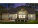 View of back exterior at dusk with screened porch, large yard, and mature trees at 330 Hidden Lake Dr, Youngsville, NC 27596