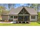 View of back exterior with screened porch, large yard, and mature trees at 330 Hidden Lake Dr, Youngsville, NC 27596
