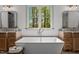 Luxurious bathroom with freestanding tub, dual vanities, and a large window with a view at 330 Hidden Lake Dr, Youngsville, NC 27596
