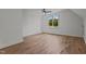 Bright bedroom features hardwood floors, ceiling fan, and a large window offering scenic outdoor views at 330 Hidden Lake Dr, Youngsville, NC 27596