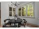 Bright breakfast nook with modern light fixture and large windows showcasing wooded backyard at 330 Hidden Lake Dr, Youngsville, NC 27596