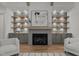 Inviting living room with a stone fireplace flanked by lit built-in cabinets and hardwood flooring at 330 Hidden Lake Dr, Youngsville, NC 27596