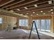 Unfinished living room featuring exposed studs, ample natural light, and sliding glass doors to the backyard at 3331 Colby Chase Dr # 8, Apex, NC 27539