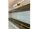 Bar area with tile backsplash, wood shelves, and brass fixtures with custom lighting above at 627 Georgetown Rd, Raleigh, NC 27608