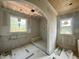 Bathroom featuring shiplap ceiling, tiled shower with bench, and two bright windows at 627 Georgetown Rd, Raleigh, NC 27608