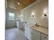 Bright bathroom featuring dual vanities with stylish lighting and wood paneled ceiling at 627 Georgetown Rd, Raleigh, NC 27608