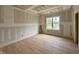 Sunlit bedroom with wood flooring and large windows offering neighborhood views at 627 Georgetown Rd, Raleigh, NC 27608