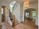 Open entryway with hardwood floors, stairs with dark iron railings, and views to open living spaces at 627 Georgetown Rd, Raleigh, NC 27608