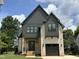 Charming two-story home with a combination of brick and black siding with a covered front porch at 627 Georgetown Rd, Raleigh, NC 27608