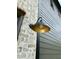 Exterior light on a house with light brick and green siding at 627 Georgetown Rd, Raleigh, NC 27608
