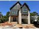 An exterior view of a two-story home featuring a brick facade, dark trim, and an attached garage at 627 Georgetown Rd, Raleigh, NC 27608