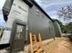 Side exterior showing gray siding and brick accents on a home under construction at 627 Georgetown Rd, Raleigh, NC 27608