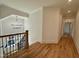Bright hallway features hardwood floors, staircase with wood banister, and elegant lighting fixtures at 627 Georgetown Rd, Raleigh, NC 27608