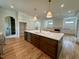 Open kitchen featuring a large island with marble countertop, stainless appliances, and hardwood flooring at 627 Georgetown Rd, Raleigh, NC 27608