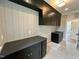 Well-equipped laundry room with black cabinets, stone countertops, and stylish wallpaper at 627 Georgetown Rd, Raleigh, NC 27608