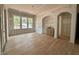 Open living room space featuring hardwood floors, large windows, and classic archways ready for finishing at 627 Georgetown Rd, Raleigh, NC 27608