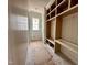 A mudroom featuring white wood paneling, a window, and a custom built-in shelving unit at 627 Georgetown Rd, Raleigh, NC 27608
