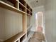 A mudroom featuring white wood paneling, a window, and a custom built-in shelving unit at 627 Georgetown Rd, Raleigh, NC 27608