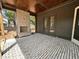 Covered patio features a stone fireplace, brick flooring and double doors to the backyard at 627 Georgetown Rd, Raleigh, NC 27608