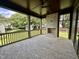 Covered porch with stone fireplace, ceiling fan, wood ceiling, and brick floors at 627 Georgetown Rd, Raleigh, NC 27608