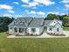 Beautiful white home with stone accents, a welcoming porch, and lush green lawn and a scenic lake view at 1618 Ben Wilson Rd, Mebane, NC 27302