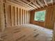 This bedroom features unfinished wood framing, a large window, and subflooring, showing the potential of a new home at 208 E Whitaker Mill Rd, Raleigh, NC 27608
