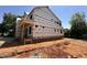 Two-story home under construction with brick foundation and Tyvek, highlighting the new construction at 208 E Whitaker Mill Rd, Raleigh, NC 27608