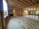 Unfinished living room area with wood framing and subflooring, with an exterior view of a house at 208 E Whitaker Mill Rd, Raleigh, NC 27608