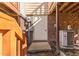Basement exit with a brick wall and an exterior door surrounded by greenery and wooden stairs at 6413 English Oaks Dr, Raleigh, NC 27615