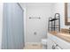 Bathroom with blue patterned shower curtain, granite countertop, and white cabinets at 6413 English Oaks Dr, Raleigh, NC 27615