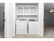 Laundry closet with shelving and white washer and dryer units at 6413 English Oaks Dr, Raleigh, NC 27615