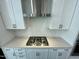 Modern gas cooktop with white shaker cabinets and herringbone backsplash at 2103 Lambert Rd # 62, Cary, NC 27519