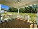 Charming back porch with wooden floorboards and white railings offers a serene view of the surrounding greenery at 235 Grand Griffon Way, Lillington, NC 27546