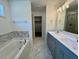 Bathroom features a double sink vanity, a soaking tub with marble surround, and a glass shower at 235 Grand Griffon Way, Lillington, NC 27546