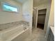 Bathroom features a soaking tub with marble surround, large window, and glass shower at 235 Grand Griffon Way, Lillington, NC 27546
