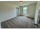 This bedroom features plush carpeting, a window for natural light and a door at 235 Grand Griffon Way, Lillington, NC 27546