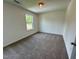 An empty bedroom with carpet, light fixture, and a window at 235 Grand Griffon Way, Lillington, NC 27546