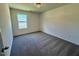 An empty bedroom with carpet, light fixture, and a double window at 235 Grand Griffon Way, Lillington, NC 27546