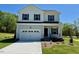 Charming two-story home with a covered front porch, an attached garage, and professionally landscaped lawn at 235 Grand Griffon Way, Lillington, NC 27546