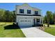 Traditional two-story home with a two-car garage, a well-manicured lawn, and classic curb appeal at 235 Grand Griffon Way, Lillington, NC 27546