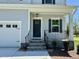 Charming home featuring a welcoming front porch and a stylish dark-colored front door at 235 Grand Griffon Way, Lillington, NC 27546
