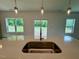 Kitchen sink with a stainless steel basin, light countertops, and a view of the backyard through the windows at 235 Grand Griffon Way, Lillington, NC 27546