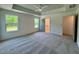 This spacious bedroom features plush carpeting, tray ceilings, and windows providing views of the outdoors at 235 Grand Griffon Way, Lillington, NC 27546