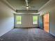 Spacious bedroom features tray ceiling, ceiling fan, plush carpeting, and bright natural light from two large windows at 235 Grand Griffon Way, Lillington, NC 27546